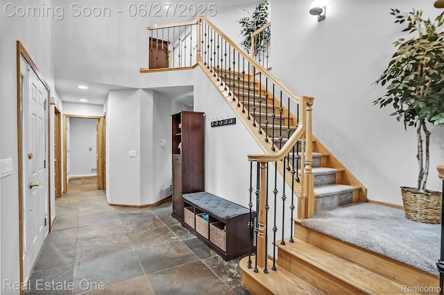 2300 Canyon Ridge Dr, White Lake, MI 48383 - stairs featuring stone tile floors, a towering ceiling, and recessed lighting