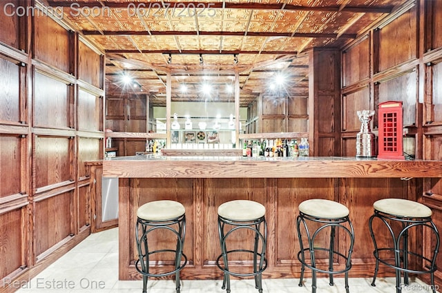 2300 Canyon Ridge Dr, White Lake, MI 48383 - indoor dry bar featuring wooden walls and light tile patterned flooring