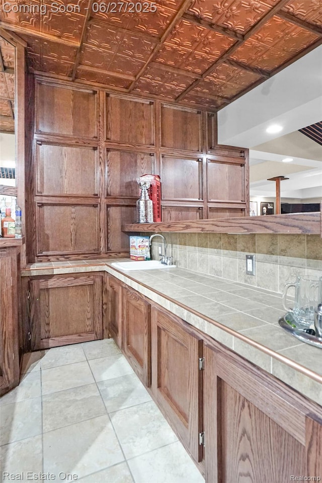 2300 Canyon Ridge Dr, White Lake, MI 48383 - kitchen featuring tile countertops, tasteful backsplash, brown cabinets, and an ornate ceiling