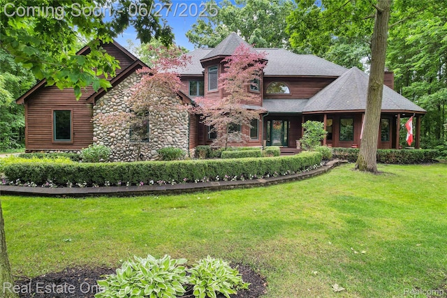 2300 Canyon Ridge Dr, White Lake, MI 48383 - view of front facade with a chimney, a front yard, and stone siding