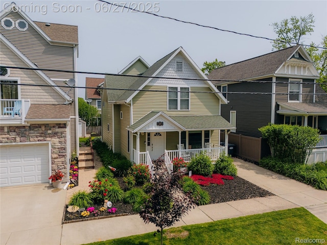 229 Huron St, South Haven, MI 49090 - victorian-style house with a porch, driveway, stone siding, an attached garage, and roof with shingles