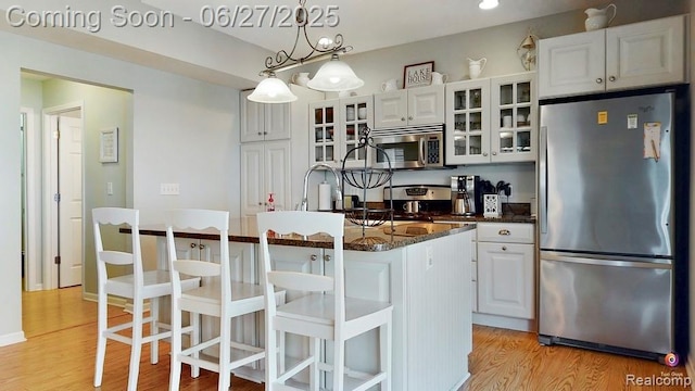 229 Huron St, South Haven, MI 49090 - kitchen featuring stainless steel appliances, light wood finished floors, white cabinetry, and glass insert cabinets