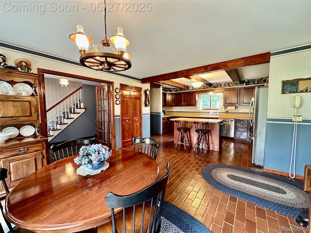 9276 Old Plank Ln, Brighton, MI 48114 - dining room featuring brick patterned flooring, a chandelier, beam ceiling, and stairway