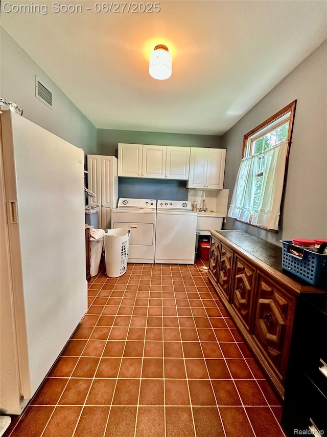 9276 Old Plank Ln, Brighton, MI 48114 - laundry area with cabinet space, separate washer and dryer, and dark tile patterned floors