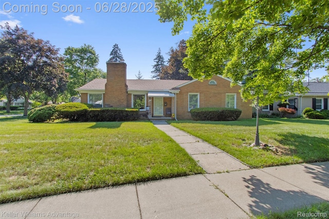 21415 Lathrup St, Southfield, MI 48075 - view of front facade with a front lawn, brick siding, and a chimney