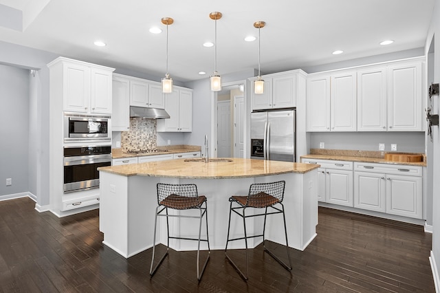 636 Wynding Oaks, Kalamazoo, MI 49006 - kitchen with appliances with stainless steel finishes, under cabinet range hood, dark wood finished floors, white cabinetry, and an island with sink