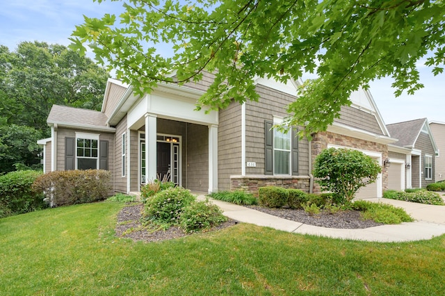 636 Wynding Oaks, Kalamazoo, MI 49006 - view of front of property featuring a front yard, an attached garage, stone siding, and driveway