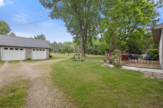 9708 Oakland Dr, Portage, MI 49024 - view of green lawn featuring dirt driveway, a wooden deck, an outdoor structure, and a garage