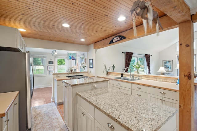 9708 Oakland Dr, Portage, MI 49024 - kitchen with freestanding refrigerator, a center island, wooden ceiling, plenty of natural light, and light tile patterned floors