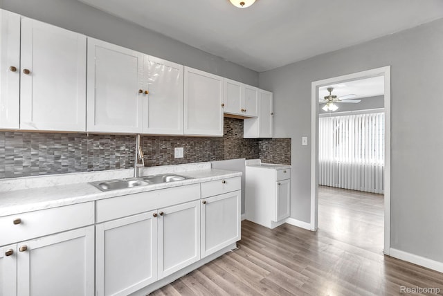 15852 Washburn St, Dearborn, MI 48238 - kitchen with white cabinetry, backsplash, ceiling fan, and light wood finished floors