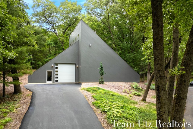 410 Greentree Ln NE, Ada, MI 49301 - view of front facade featuring driveway and a detached garage