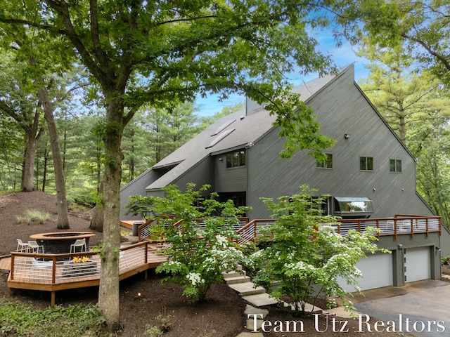 410 Greentree Ln NE, Ada, MI 49301 - view of side of property with a wooden deck, driveway, and a garage