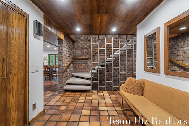410 Greentree Ln NE, Ada, MI 49301 - stairway with brick wall, wooden ceiling, recessed lighting, and tile patterned floors