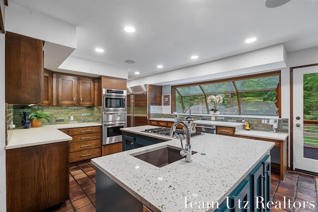 410 Greentree Ln NE, Ada, MI 49301 - kitchen featuring stainless steel appliances, tasteful backsplash, a center island with sink, recessed lighting, and light stone counters