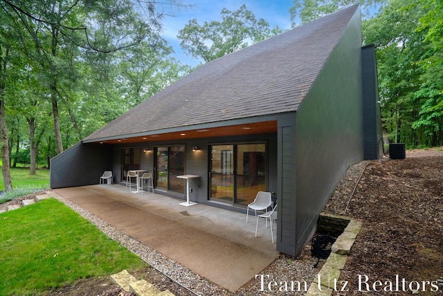 410 Greentree Ln NE, Ada, MI 49301 - back of property with a shingled roof and a patio area