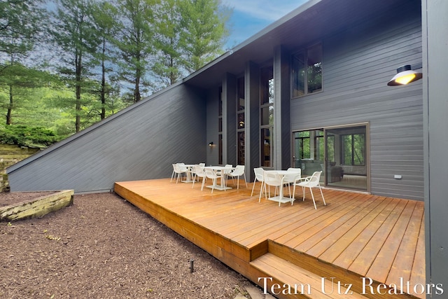 410 Greentree Ln NE, Ada, MI 49301 - wooden terrace with outdoor dining area