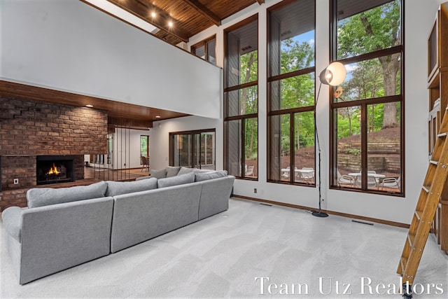 410 Greentree Ln NE, Ada, MI 49301 - living room with a towering ceiling, a wood ceiling with exposed beams, a fireplace, and carpet