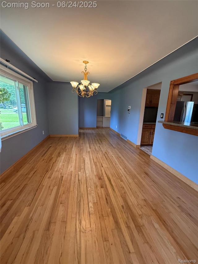 53240 Odilon Ave, Shelby Twp, MI 48316 - spare room with a chandelier and light wood-style floors