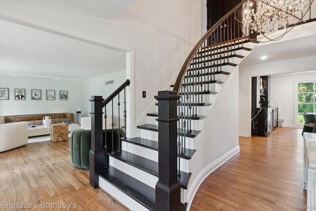 4438 Stony River Dr, Bloomfield Hills, MI 48301 - staircase featuring wood finished floors, a chandelier, and crown molding