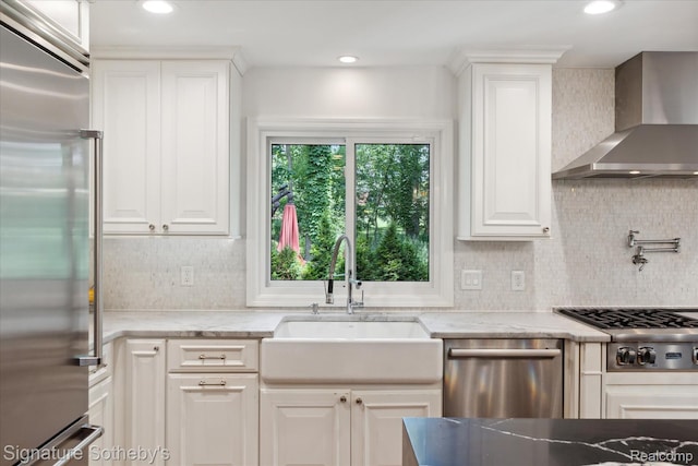4438 Stony River Dr, Bloomfield Hills, MI 48301 - kitchen with stainless steel appliances, wall chimney exhaust hood, tasteful backsplash, light stone countertops, and recessed lighting