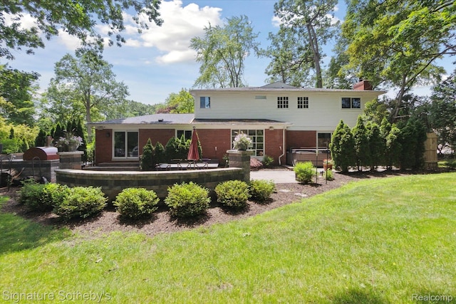 4438 Stony River Dr, Bloomfield Hills, MI 48301 - rear view of property featuring a hot tub, a lawn, a patio area, a chimney, and brick siding