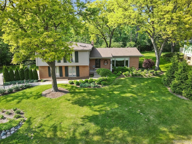 2650 Binbrooke Dr, Troy, MI 48084 - split level home with brick siding, a front yard, and a chimney