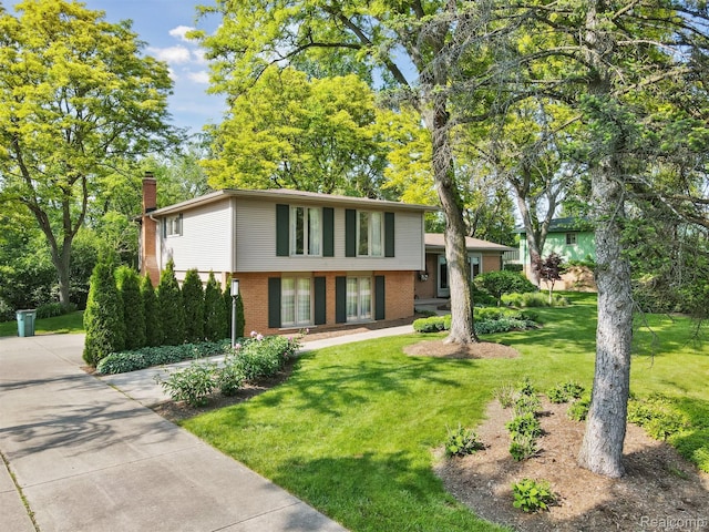2650 Binbrooke Dr, Troy, MI 48084 - split level home featuring a chimney, brick siding, and a front lawn