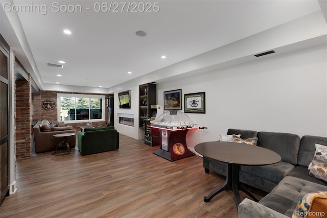 8264 Stoney Creek Dr, South Lyon, MI 48178 - living room featuring a glass covered fireplace, wood finished floors, and recessed lighting