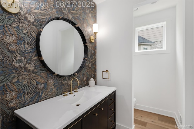 8264 Stoney Creek Dr, South Lyon, MI 48178 - half bath with wallpapered walls, wood finished floors, and vanity