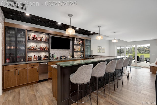 8264 Stoney Creek Dr, South Lyon, MI 48178 - indoor wet bar with light wood-style flooring, hanging light fixtures, recessed lighting, decorative backsplash, and stainless steel dishwasher