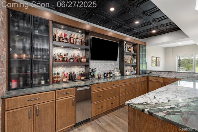 8264 Stoney Creek Dr, South Lyon, MI 48178 - indoor wet bar featuring light wood-type flooring and dishwasher