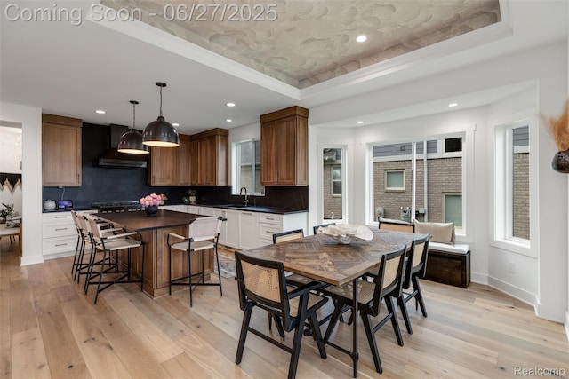 8264 Stoney Creek Dr, South Lyon, MI 48178 - dining room featuring a raised ceiling, light wood-style floors, recessed lighting, and ornamental molding