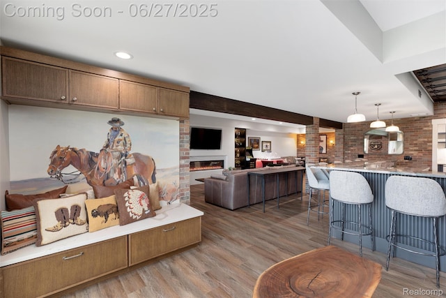 8264 Stoney Creek Dr, South Lyon, MI 48178 - living area featuring light wood finished floors, a glass covered fireplace, and recessed lighting