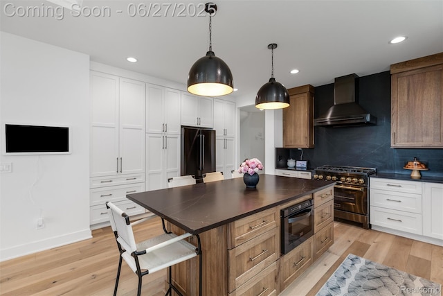 8264 Stoney Creek Dr, South Lyon, MI 48178 - kitchen featuring wall chimney exhaust hood, range with two ovens, dark countertops, fridge, and recessed lighting