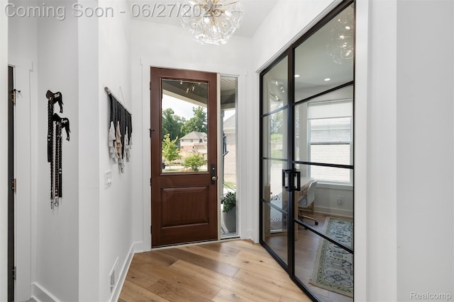 8264 Stoney Creek Dr, South Lyon, MI 48178 - foyer entrance featuring light wood-style floors, a chandelier, and healthy amount of natural light