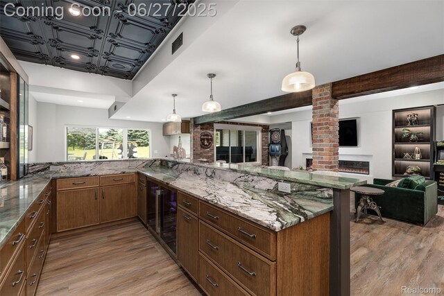 8264 Stoney Creek Dr, South Lyon, MI 48178 - kitchen with light wood-type flooring, stone countertops, open floor plan, wine cooler, and beamed ceiling