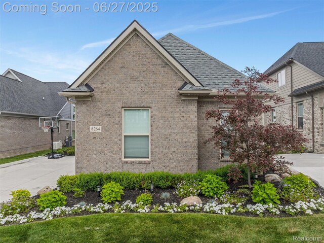 8264 Stoney Creek Dr, South Lyon, MI 48178 - view of side of property featuring brick siding, roof with shingles, and a yard