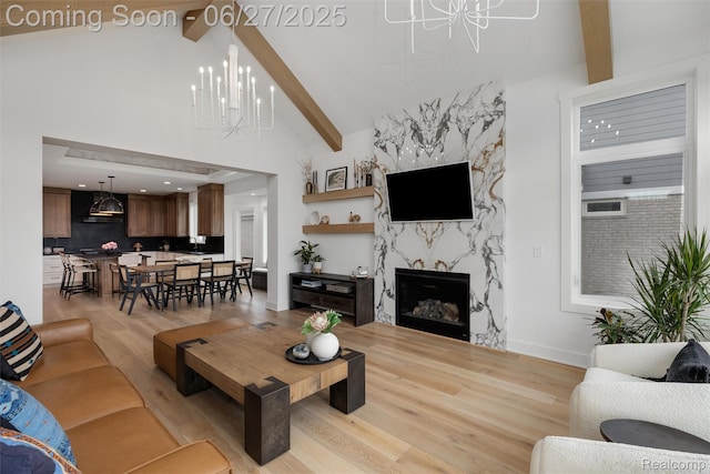 8264 Stoney Creek Dr, South Lyon, MI 48178 - living room with a chandelier, light wood-type flooring, beamed ceiling, a fireplace, and high vaulted ceiling