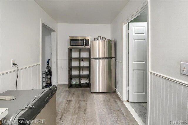 8021 Benson Rd, Mount Morris, MI 48458 - kitchen featuring appliances with stainless steel finishes, light wood finished floors, and wainscoting
