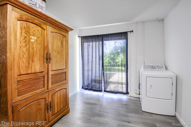 8021 Benson Rd, Mount Morris, MI 48458 - washroom with washer / clothes dryer, wood finished floors, and cabinet space
