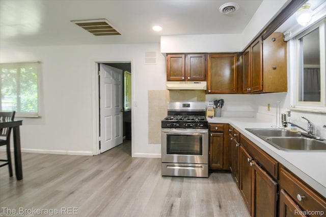 8021 Benson Rd, Mount Morris, MI 48458 - kitchen with stainless steel range with gas cooktop, under cabinet range hood, light wood-type flooring, and light countertops