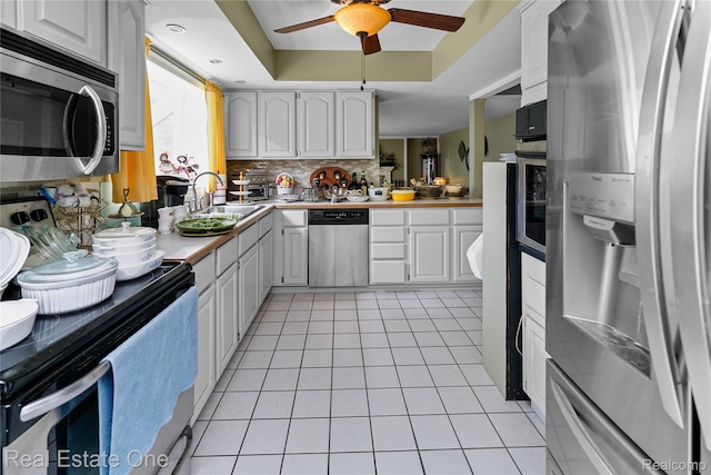 21462 Meridian Rd, Grosse Ile, MI 48138 - kitchen featuring appliances with stainless steel finishes, ceiling fan, light tile patterned floors, light countertops, and white cabinetry