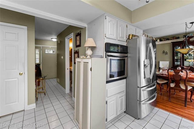 21462 Meridian Rd, Grosse Ile, MI 48138 - kitchen featuring stainless steel appliances, light tile patterned floors, and white cabinetry