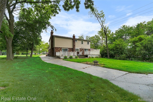 21462 Meridian Rd, Grosse Ile, MI 48138 - back of property with a chimney, a wooden deck, a lawn, and brick siding