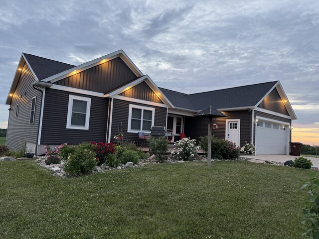 21491 8th Ave, Conklin, MI 49403 - view of front of property with board and batten siding, a garage, a front lawn, and driveway