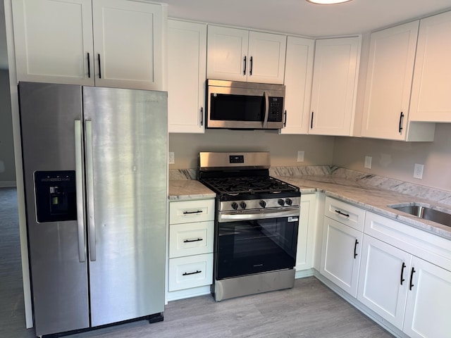 2159 E Eden Ct, Ann Arbor, MI 48108 - kitchen featuring stainless steel appliances, white cabinetry, and light wood-style floors