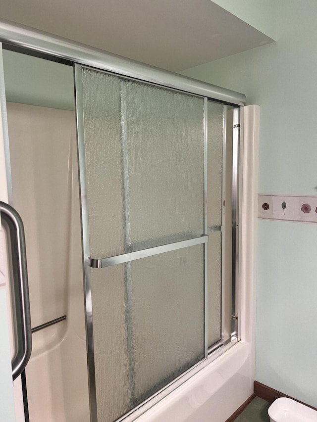 5804 Leisure S Dr SE, Grand Rapids, MI 49548 - bathroom featuring toilet and shower / bath combination with glass door