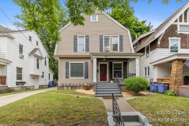 109 Fuller Ave SE, Grand Rapids, MI 49506 - view of front facade featuring a porch, a front lawn, a gambrel roof, and cooling unit