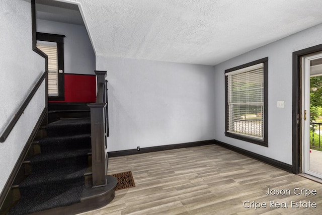 109 Fuller Ave SE, Grand Rapids, MI 49506 - staircase featuring a textured ceiling and wood finished floors