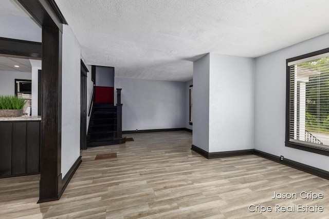 109 Fuller Ave SE, Grand Rapids, MI 49506 - unfurnished room featuring light wood-style floors, a textured ceiling, and stairs